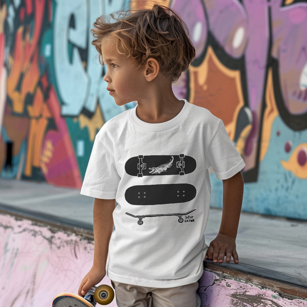 a young boy holding a skateboard in front of a graffiti covered wall